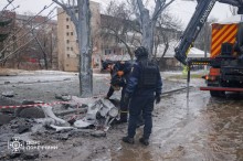 Працівники ДСНС обстежують місце потрапляння півторатонної авіабомби. На землі лежать залишки ворожої авіаційної бомби.