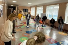 Учасники тренінгу виконують вправу в колі в ігровій зоні з розвивальними елементами на підлозі.