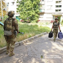 Поліцейський несе речі людей