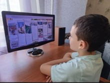 Хлопчик з Костянтинівської громади за ноутбуком під час віртуальної екскурсії Ужгородом