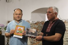 Начальник Миколаївської міської військової адміністрації Володимир Проскунін, дарує книгу «Пункт дислокації Донбас» голові Коломийської міської територіальної громади Богдану Станіславському. Чоловіки одягнені у вишиванки.