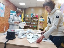 Жінки нарізають білу тканину для маскувальних сіток