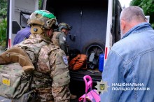Поліцейські допомагають людям сісти в евакомобіль