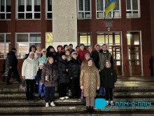 Група людей стоїть на сходах перед Народним домом міста Шептицький, позуючи для спільного фото ввечері