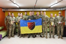 Вадим Філашкін тримає прапор разом з бійцями 55-ої артилерійської бригади