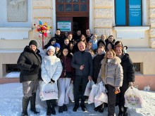 Молодь Новогродівської громади на Прикарпатті. Хлопці та дівчата стоять біля фасаду будинку, тримають пакети у руках.
