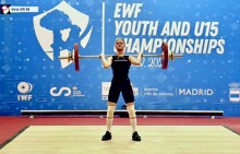 Спортсменка піднімає штангу