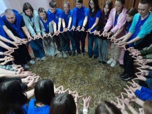 Діти стоять колом із витягнутими руками під час відпочинку