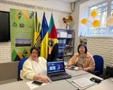 Представники військової адміністрації сидять за столом та слухають доповідача на семінарі