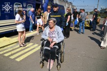 Рятувальник везе жінку на кріслі колісному на вокзалі