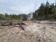 Зруйнована будівля, воронка та обгорілі дерева після ворожого обстрілу