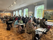 Юні донеччани та українські Захисники працюють над творчими роботами під час зустрічі в художньому музеї.