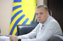 Олександр Шевченко сидить за столом під час наради
