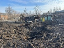 Воронка від ворожого обстрілу та зруйнований будинок