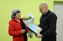 Юрій Винокуров вітає працівницю ЖКГ, дарує квіти та вручає почесну грамоту.