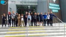 Спільне фото дітей біля фасаду пластового центру. Хлопці тримають один одного за плечі.