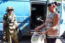 Жінка з папугою сідає в евакомобіль
