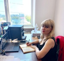 Представник військової адміністрації сидить за столом та слухає доповідача на семінарі