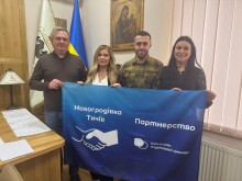 Спільне фото представників двох громад. Попереду прапор з назвами.