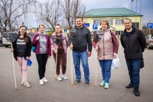 Учасники акції, тримають у руках садовий інвентар, спільне фото