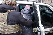 Поліцейський підрозділу «Білий янгол» допомогає жінці сідати у бронюваний автомобіль.