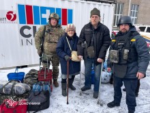 Рятувальники групи "Фенікс" поруч з чоловіком та дінкою літнього віку з палицями та купою речей