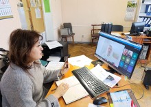 Представник військової адміністрації сидить за столом та слухає доповідача на семінарі