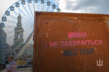 Металеві ворота, на яких надпис "Війна не закінчиться без тебе ".
Фотовиставка на Контрактовій площі, місто Київ.