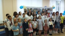 Група дітей, батьків та освітян у святковому одязі під час колективної фотосесії.