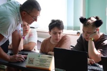 Майстер-клас з 3D-моделювання. Дівчина сидить біля ноутбуку, поруч вчитель допомагає розробляти дизайн.