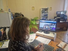 Представник військової адміністрації сидить за столом та слухає доповідача на семінарі