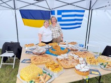 Дві жінки в наметі біля столу з різними національними смаколиками