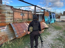 Правоохоронець стоїть біля зруйнованого окупантами паркану