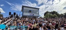 Трибуни вболівальників. Жінки та чоловіки спостерігають за змаганням.