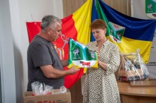 Голови громад обмінюються прапорами громад. Позаду них прапори Тур'є-Реметівської громади та Миколаївської міської військової адміністрації.