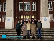 Спільне фото. ВПО з Донеччини біля фасаду будинку, стоять на сходах.