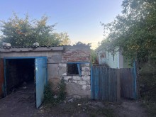 Гараж та ворота, пошкоджені ворожим обстрілом.