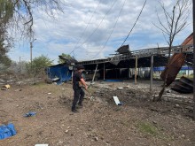 Правоохоронець стоїть біля зруйнованого окупантами господарського приміщення