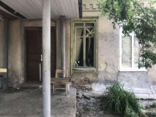Будинок з вибитим через ворожий обстріл вікном.