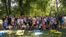 Велика група дітей-переселенців разом з організаторами заходу «Туризм крокує Україною» на природі, з луками.