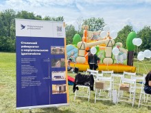 Банер університету на локації фестивалю, позаду - дитячий надувний батут та люди з повітряними кульками