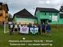 Спільне фото біля воріт на футбольному полі ветеранів з прапорами громад