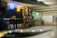 Військові проводять презентацію для молоді в межах проєкту «Наша Донеччина. Наш дім. Наша фортеця». На екрані — емблеми бойових підрозділів.