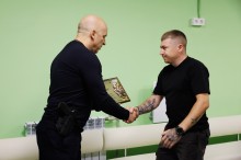 Вадим Філашкін вручає ветерану сертифікат на отримання житла.