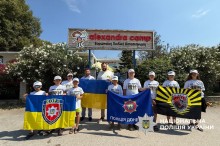 Спільне фото дітей, які тримають прапори. Стоять у білих футболках та кепках