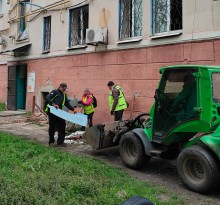 Добровольці допомагають прибирати наслідки ворожого обстрілу та завантажують будівельне сміття у трактор