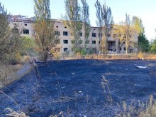 Зруйнований будинок та обгоріла трава поруч із ним