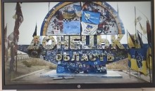 На екрані - стела Донеччини. Поруч прапори: України та військових бригад, які боронять Донецьку область.