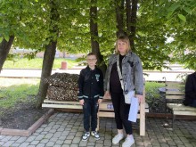 Жінка з хлопчиком фотографуються для звіту, що отримали гуманітарну допомогу