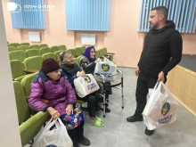 Заступник начальника Часовоярської міської військової адміністрації Руслан Прийменко, спілкується з людьми похилого віку,які тримають гуманітарні набори.